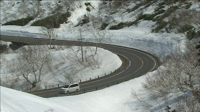 一辆汽车在蜿蜒的雪道上行驶。视频素材