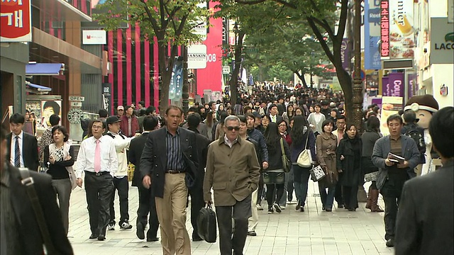 韩国明洞市中心的人行道上挤满了行人。视频素材