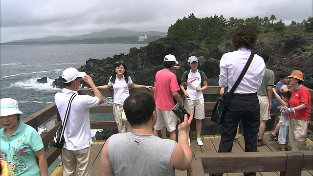 游客在Jeju-do海岸的一个观景点拍照。视频素材