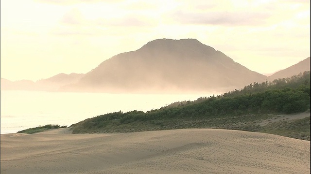 轮廓分明的山脉俯瞰着日本海和鸟取沙丘。视频素材