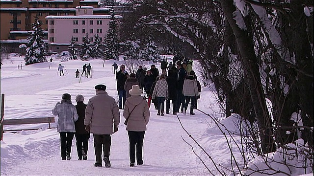 游客们走在雪道上。视频素材