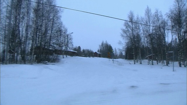 在瑞典哈帕兰达，厚厚的积雪覆盖了一个乡村社区和道路。视频素材