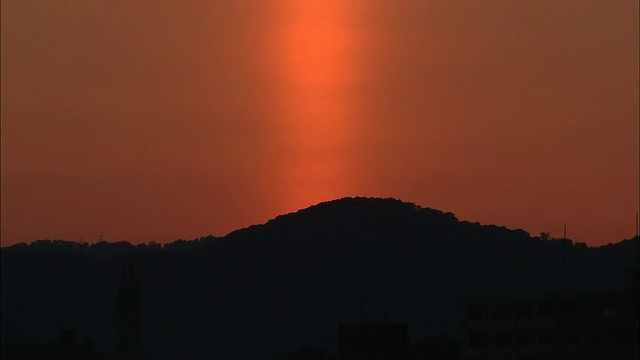 在日本，一个橙色的太阳柱在山巅发光。视频素材