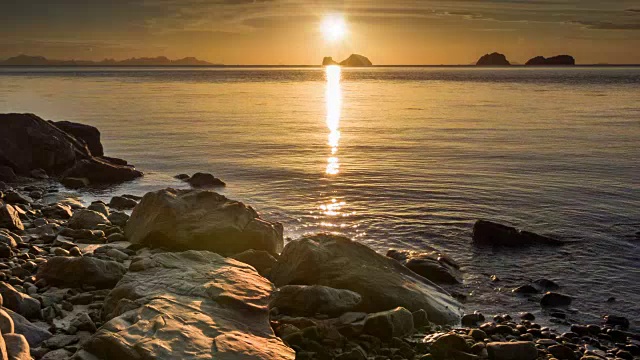 平静的海面在日落岩石海滩视频素材