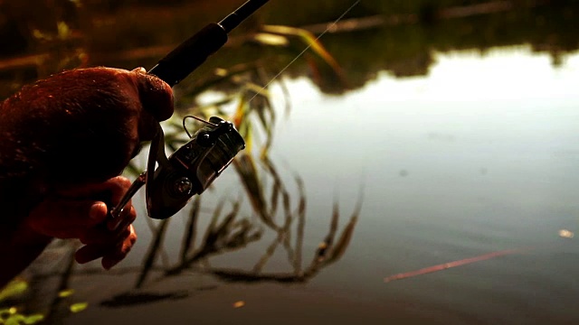 一名业余渔民手里拿着一根纺纱棒的慢镜头视频素材