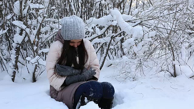 美丽可怜的小女孩已经冻在雪堆里了，在白雪覆盖的树下视频素材