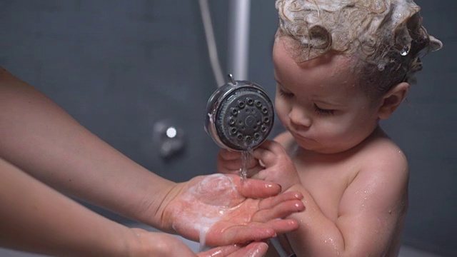 可爱漂亮的宝宝用香波在头发上帮妈妈洗手视频下载
