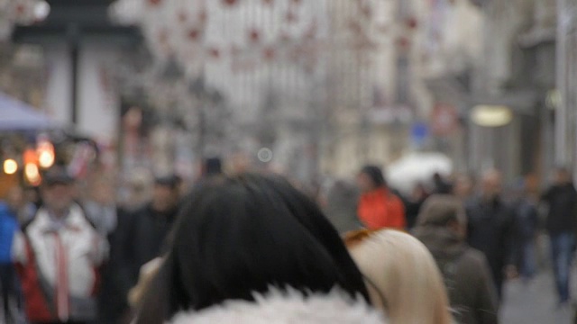 贝尔格莱德拥挤的街道。人们走路，高峰时间，秋天。专注于街头小贩装饰糖果视频素材