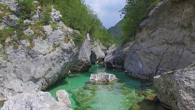 AERIAL:令人惊叹的绿松石河流流过山谷中的巨石视频素材