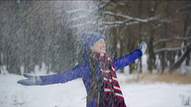 年轻快乐的女人正在抛雪。视频素材