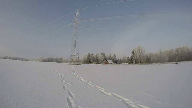 在雪堆期间，带有电塔和红色家园的景观，时间流逝视频素材