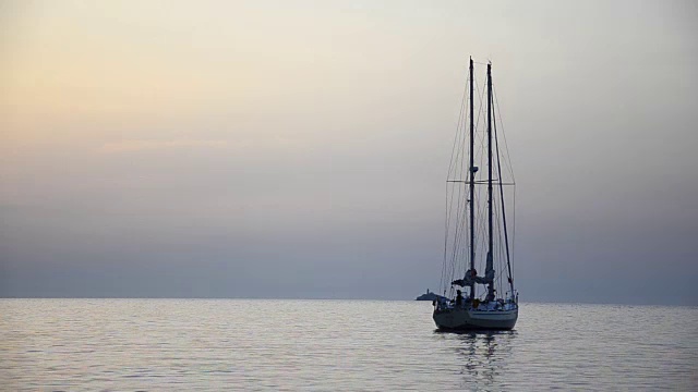 带倒影的帆船扬起风帆，在夕阳西下的海面上滑翔视频素材