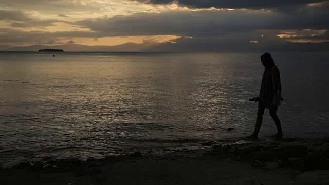 海滩上女人的落日剪影视频素材