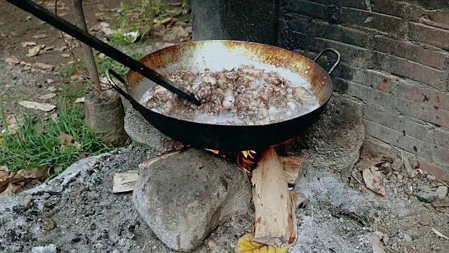 用木棒在锅里翻炒猪肉视频素材