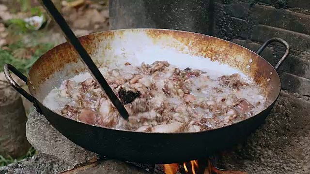 用木棒在锅里翻炒猪肉视频素材