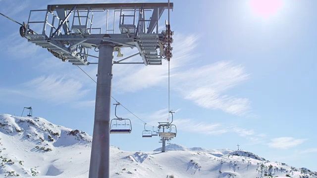 在多雪的冬天，在阳光明媚的高山滑雪场乘坐缆车视频素材