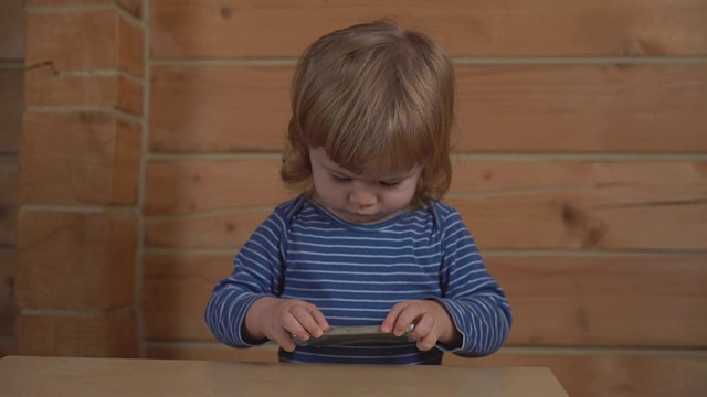 小卷毛宝宝在木屋里看手机视频下载