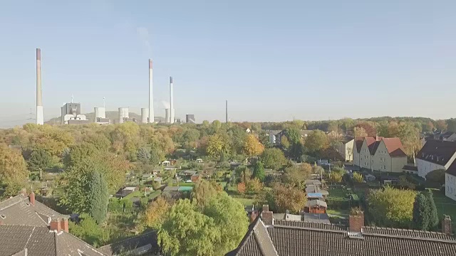 高空拍摄的是一个废弃的地区，在德国的煤矿小镇Gladbeck，低海拔，长跟踪镜头，在草地上，然后慢慢上升，在破旧的房子结束了一个工作的发电厂和分配的花园，记录在平的s-原木。视频素材