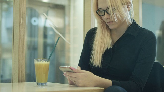 一个女人正在咖啡馆里看电话邮件视频素材