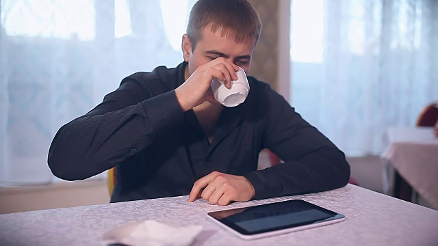 男人拿着你的平板电脑在咖啡馆上网喝咖啡视频素材