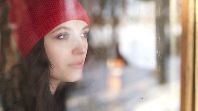 悲伤的女人看着雨水透过窗户落在家里或酒店视频素材