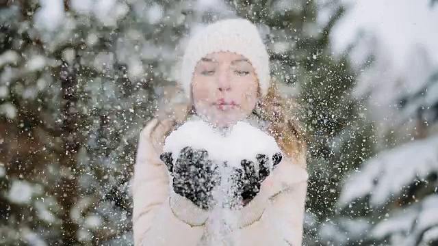 冬天的女人帽子会把手上的雪吹掉视频素材