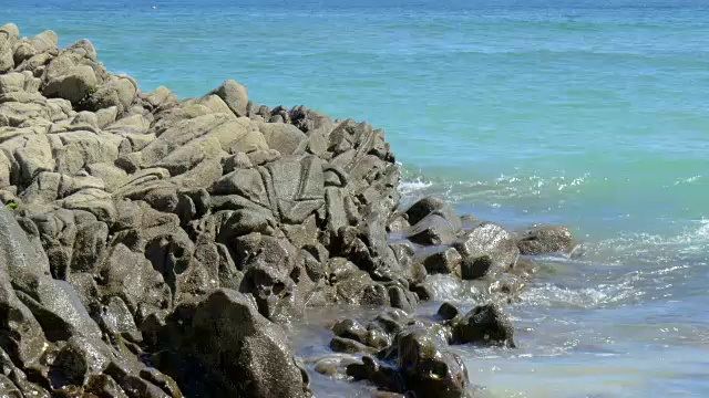 从岩石海岸溅起的水花中迅速消失。视频下载