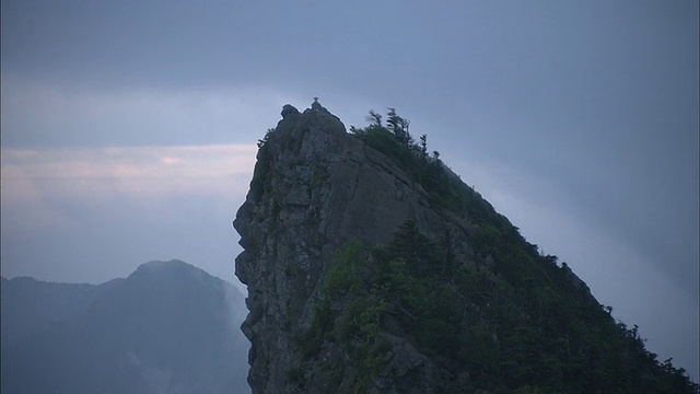 从石沼山(Mount Ishizuchi, Ehime)的山顶和山脊上飘过的漩涡云中缩小视频素材