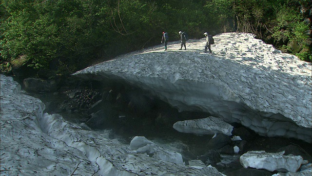 北海道大濑山国家公园，徒步者在山溪上的岩石上行走视频素材