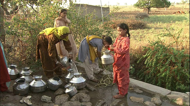 在印度，村民们把水倒进铁桶里视频素材