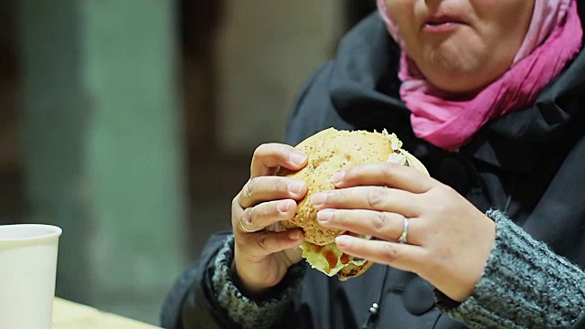 胖女人在快餐店吃饭，营养不良有害健康视频素材