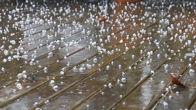 在暴风雨天气下，冰雹和雨水落在木头上视频素材