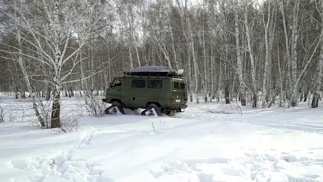 雪地摩托在冬天的树林里穿过厚厚的雪堆视频素材