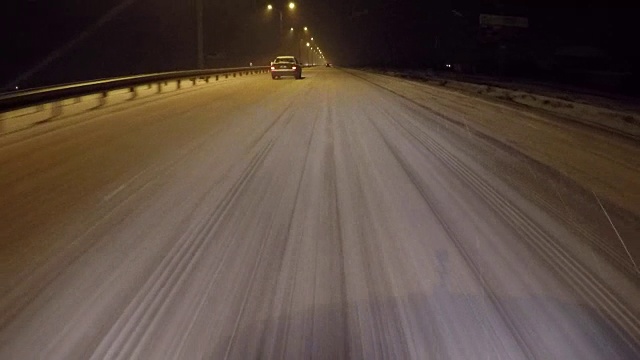 夜晚的路上有强烈的暴风雪在移动汽车前灯。视频素材