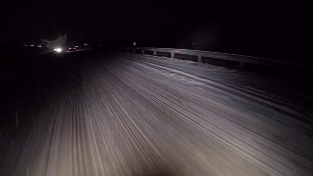 夜晚的路上有强烈的暴风雪在移动汽车前灯。视频素材