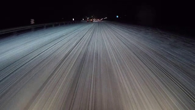 夜晚的路上有强烈的暴风雪在移动汽车前灯。视频素材