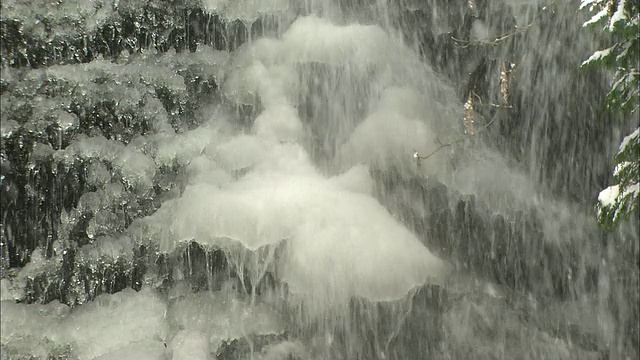 日本长野的黑泽河瀑布上飘落着雪花。视频素材