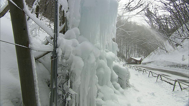 在长野轻井泽，一个洒水器正在向一个雪围栏附近喷洒人工冰柱。视频素材