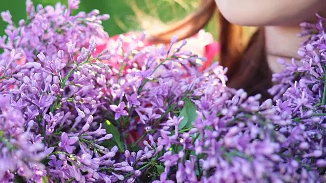 美丽微笑的年轻女子，手捧丁香花束户外视频素材