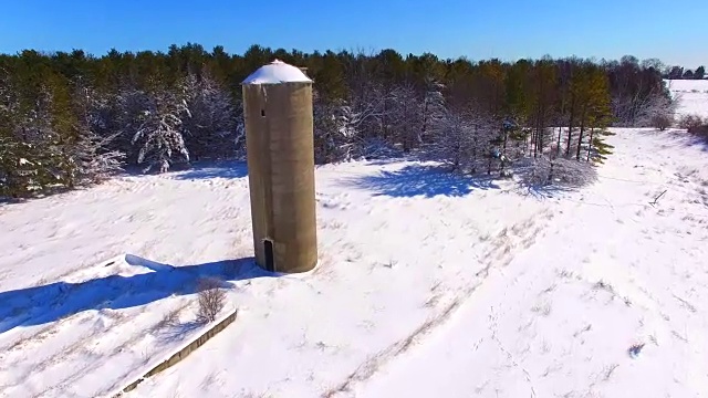 白雪覆盖的树林和废弃的筒仓视频素材