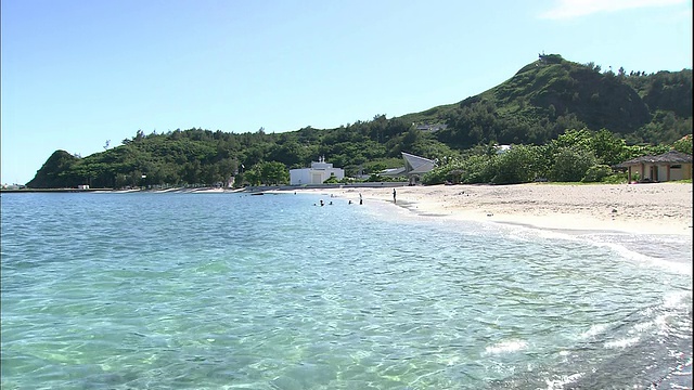 在Chichijima岛的海滩上，海滩游客涉水进入太平洋。视频素材