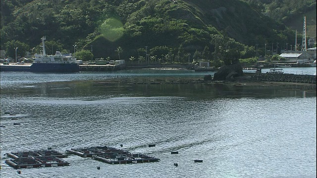 在日本Chichijima岛海岸的双美湾，水中养殖笼子漂浮着。视频素材