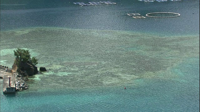 一条堤道伸入日本集子岛珊瑚礁附近的双美湾。视频素材