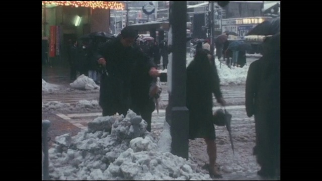 行人小心翼翼地走过银座4丁目十字路口的雪地。视频素材