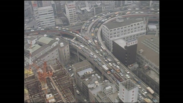 拥挤的交通缓慢地移动通过江户桥的都市高速公路内环线在中央，东京。视频素材