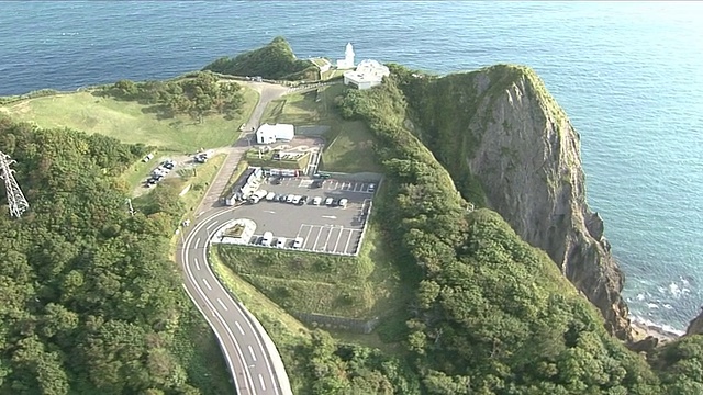 日本北海道千球角，海浪冲击着灯塔底部的悬崖。视频素材