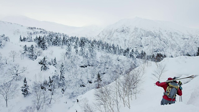 滑雪者沿着陡峭的斜坡往下爬视频下载