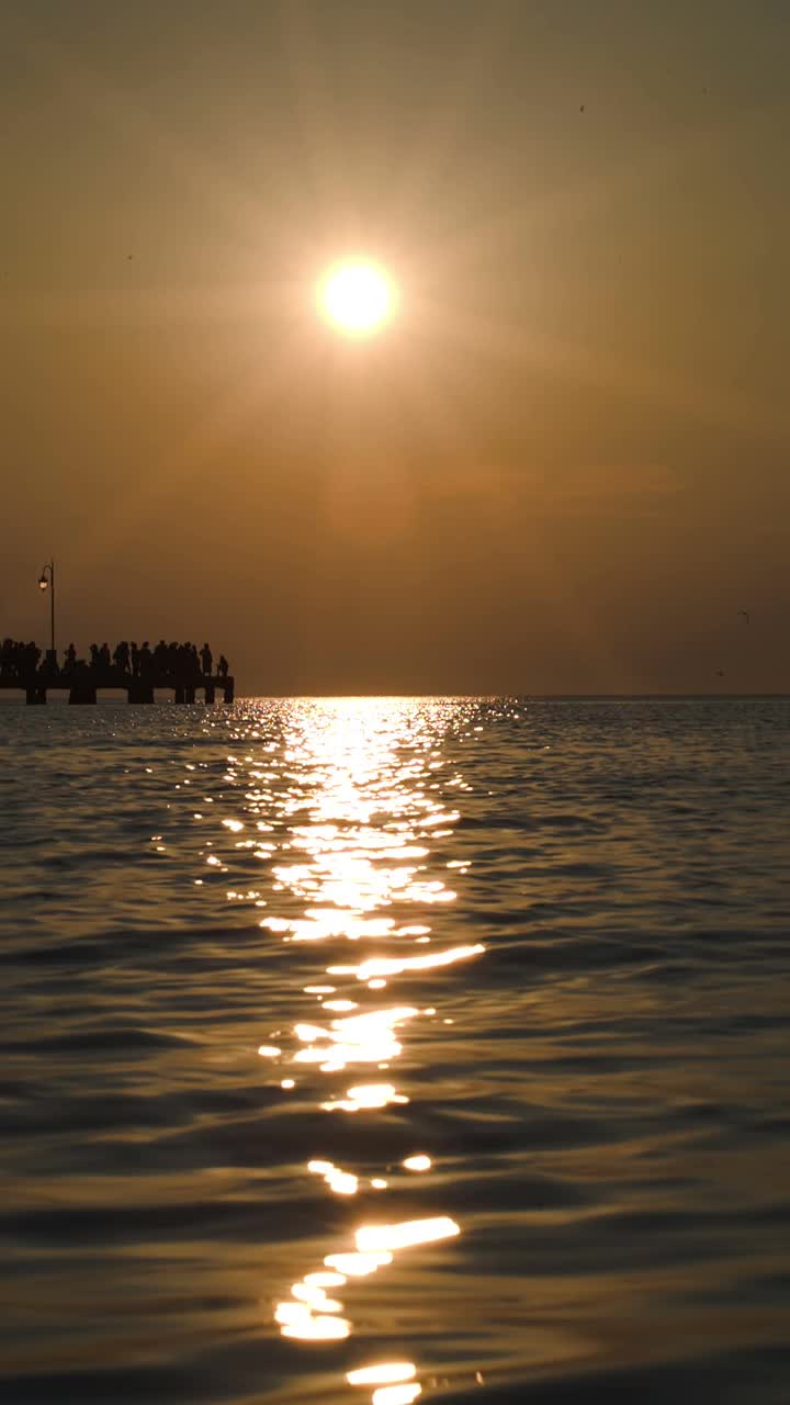 夕阳下远处码头上的人们视频素材