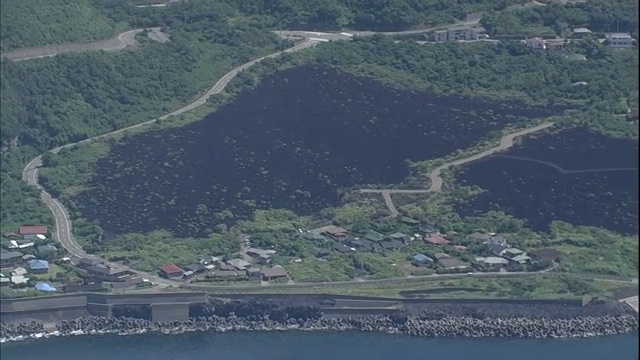 三宅岛火山喷发后，黑色熔岩残留在海岸线附近。视频素材