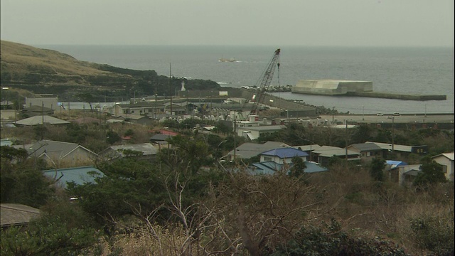 一艘渔船驶出日本三宅岛的港口。视频素材